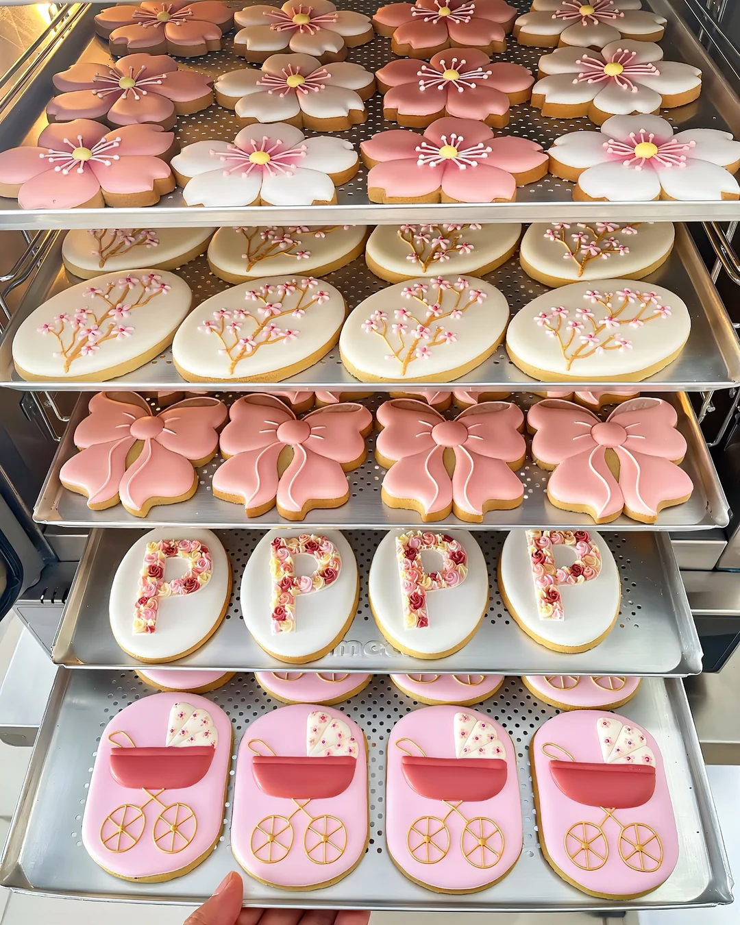 Bandejas do ateliê com biscoitos artesanais decorados à mão com flores e laços