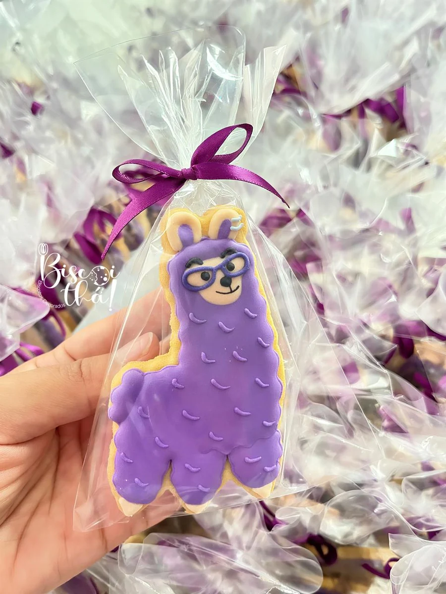 Biscoito de personagem roxo com glacê real e laço, em uma encomenda de festa