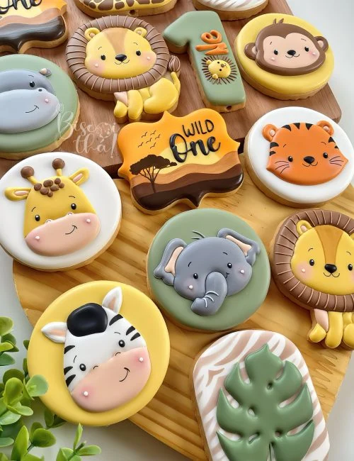Biscoitos decorados em formato de leão, elefante, girafa e zebra em uma coleção safári